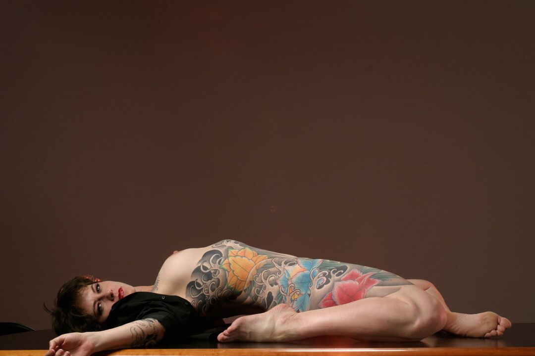 15P La mujer tatuada Michelle Aston realiza estupendas poses semidesnudas sobre una mesa