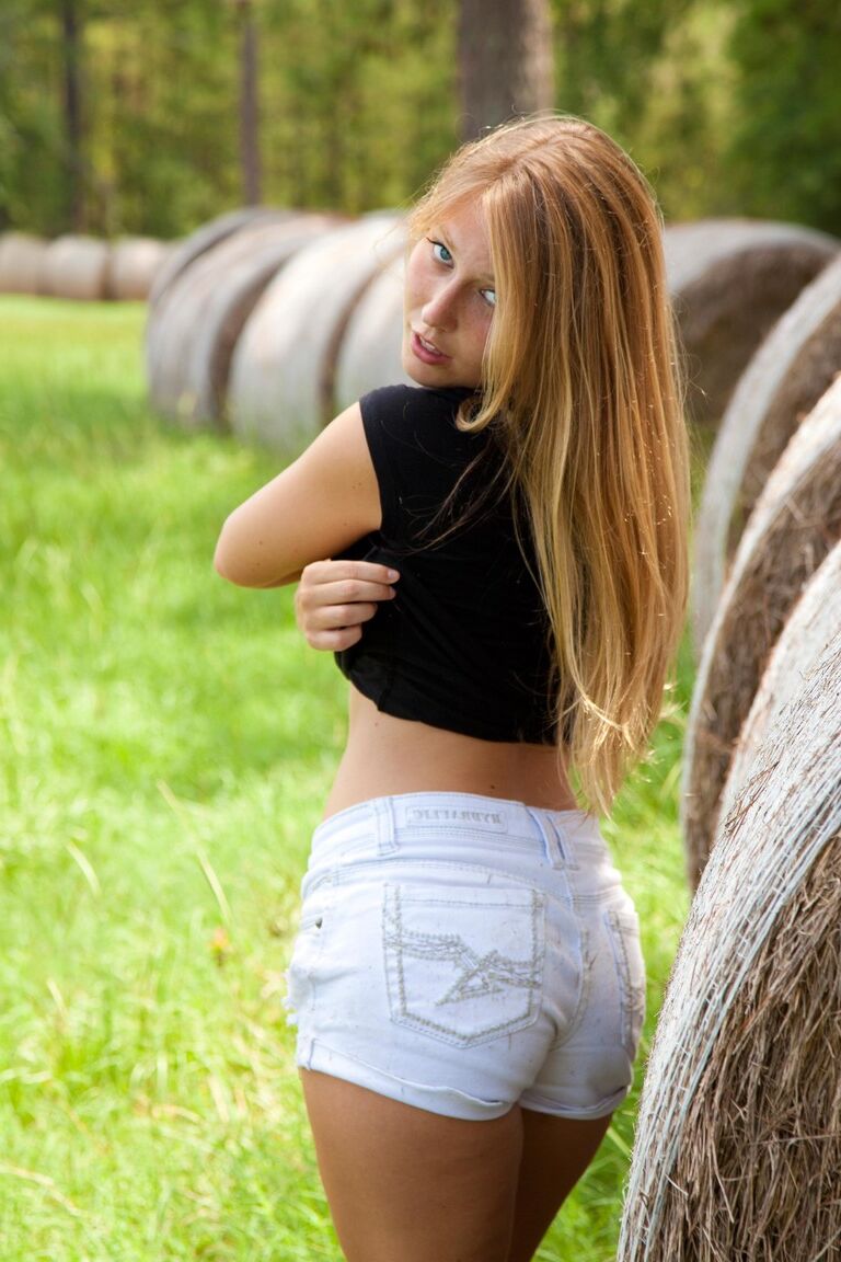 21P La belle adolescente Breen se déshabille dans le champ de foin et pose les fesses nues