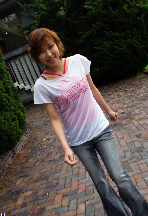 16P Madoka Ozava, une jeune japonaise rousse, se met totalement nue sur son lit.