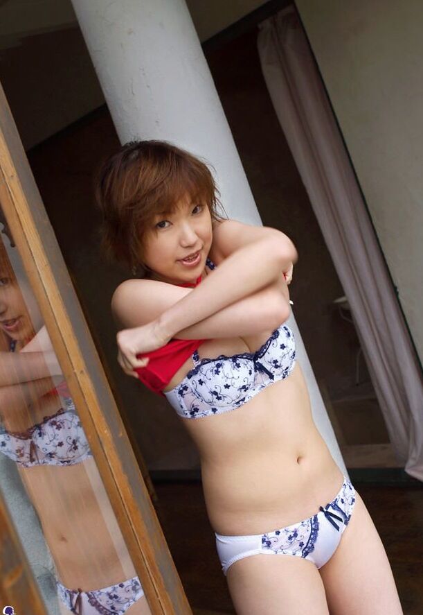 16P Madoka Ozava, une jeune japonaise rousse, se met totalement nue sur son lit.