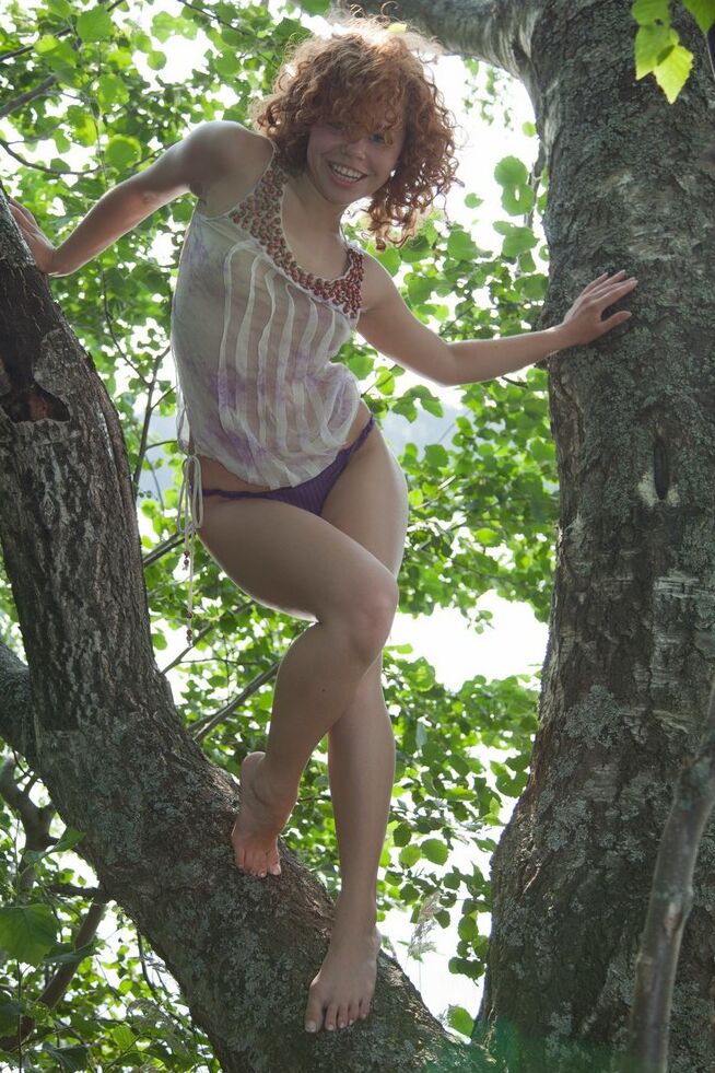 15P Joven pelirroja hace alarde de su culo sexy y abre su coño en un árbol