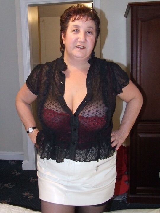 20P Chubby older lady Kinky Carol slips a miniskirt over her thong clad butt