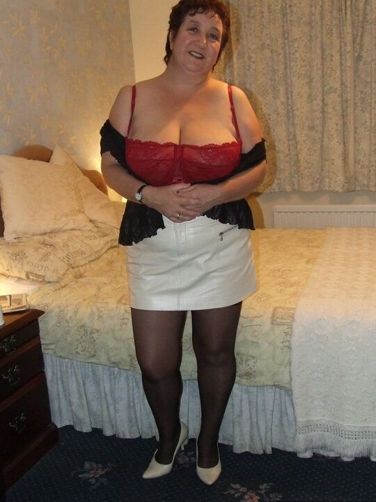 20P Chubby older lady Kinky Carol slips a miniskirt over her thong clad butt