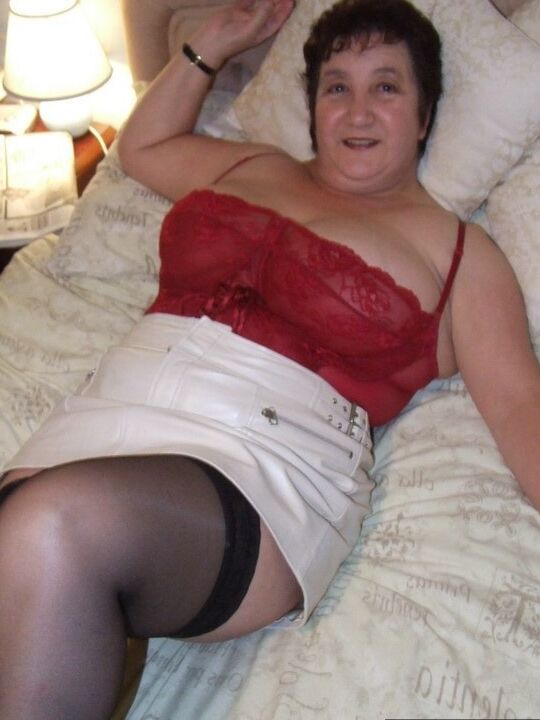 20P Chubby older lady Kinky Carol slips a miniskirt over her thong clad butt