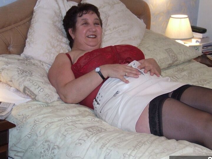 20P Chubby older lady Kinky Carol slips a miniskirt over her thong clad butt