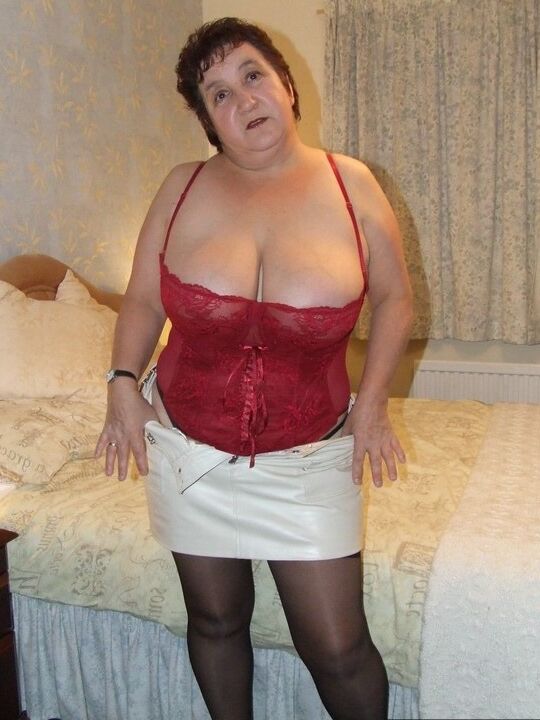 20P Chubby older lady Kinky Carol slips a miniskirt over her thong clad butt