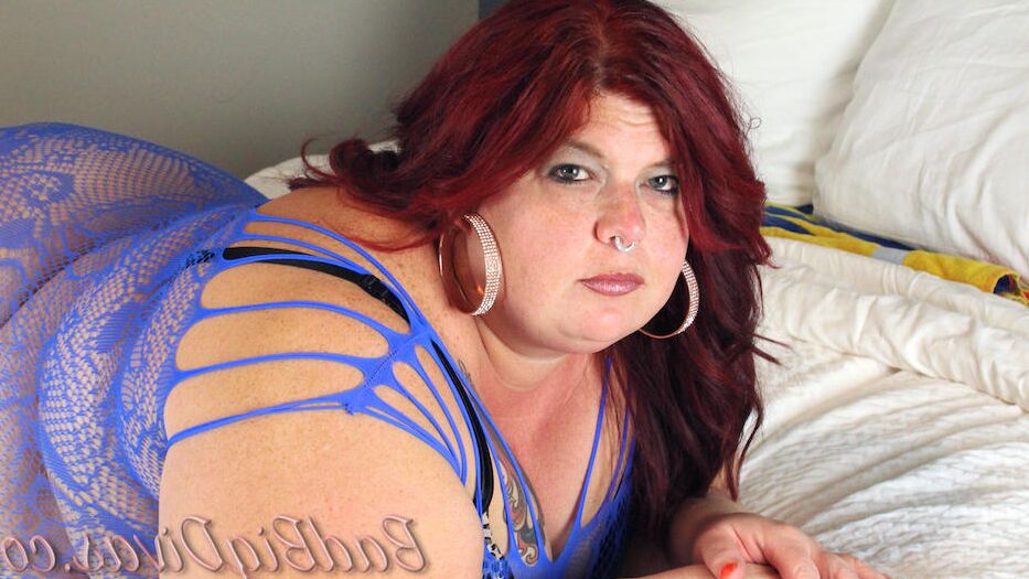 11P Redhead SSBBW Nikki Cakes models a bodystocking in her bedroom
