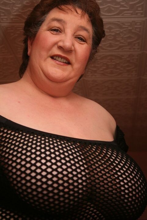 20P Mulher mais velha e grossa, Kinky Carol, ostenta cabelo curto enquanto modela um vestido de malha