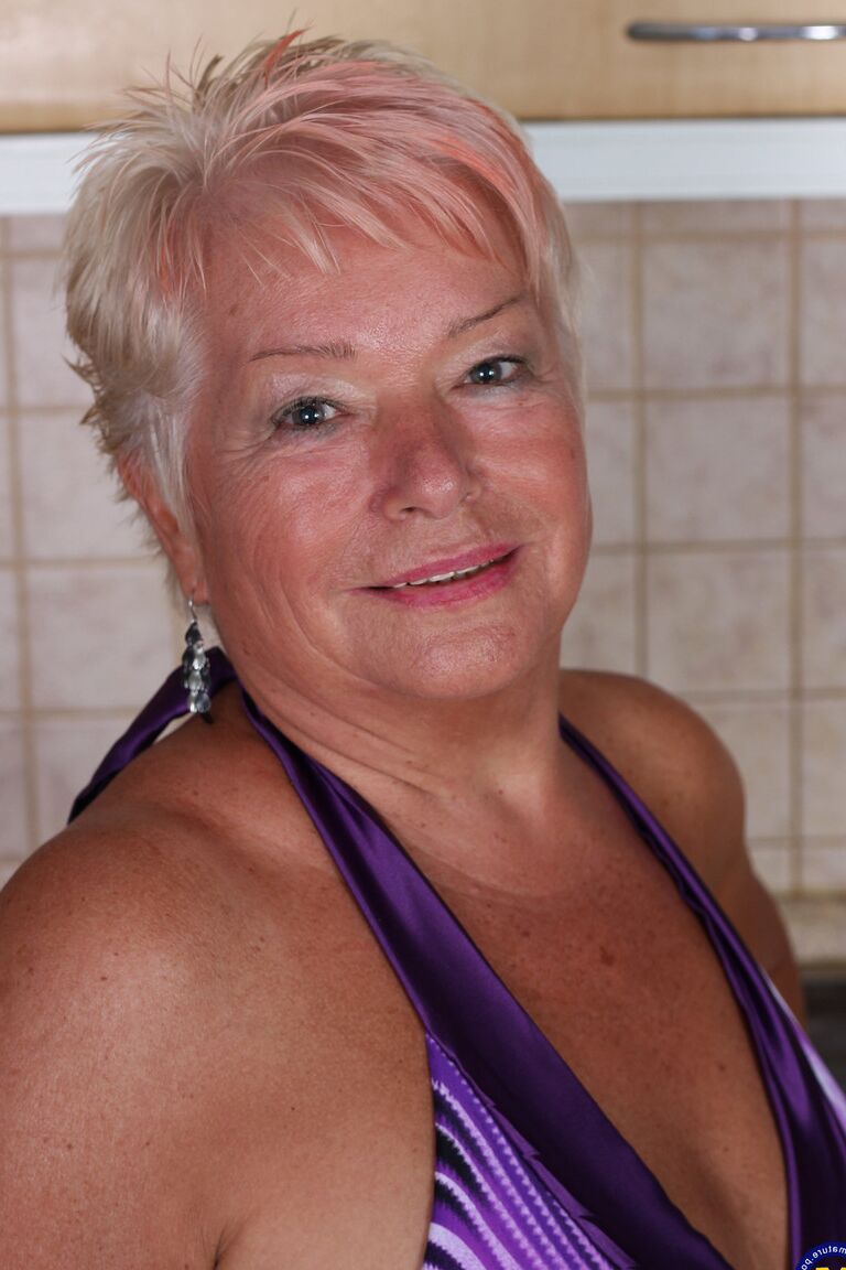 21P Short haired granny Verona M strips in the kitchen and fingers her old snatch
