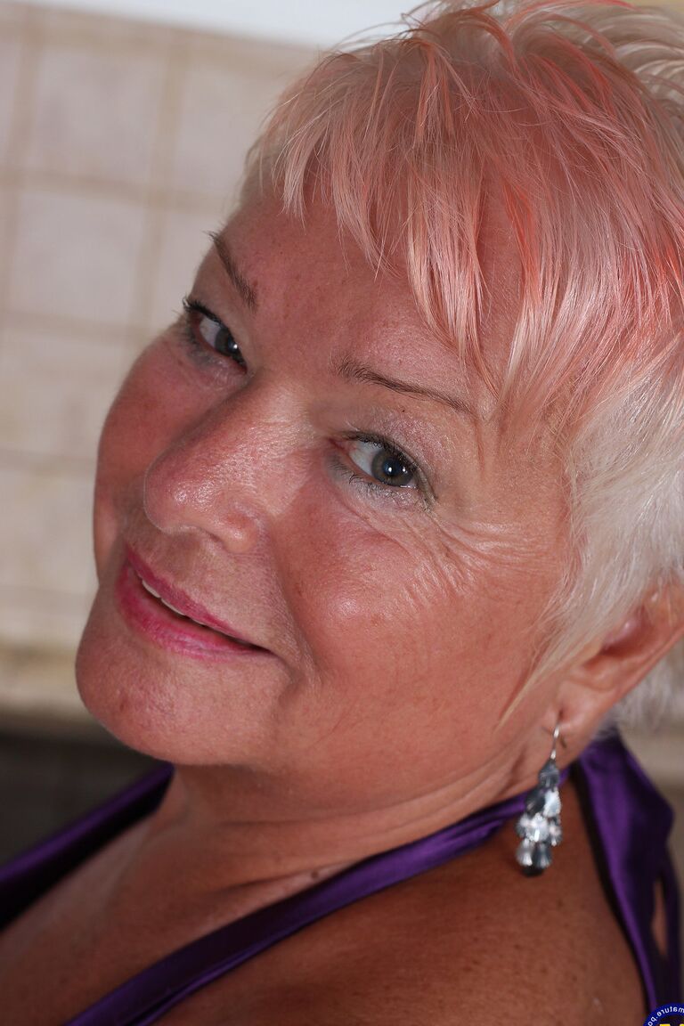 21P Short haired granny Verona M strips in the kitchen and fingers her old snatch