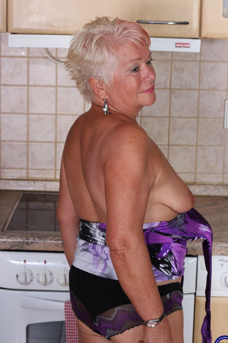 21P Short haired granny Verona M strips in the kitchen and fingers her old snatch