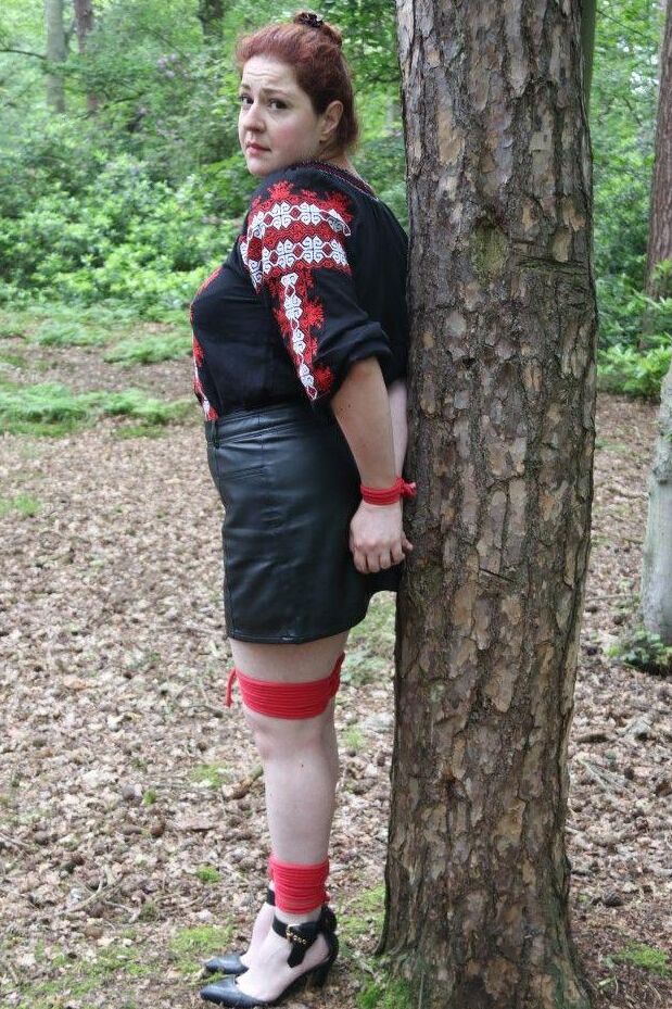 16P Thick redhead is cleave gagged and tied to a tree in a forest