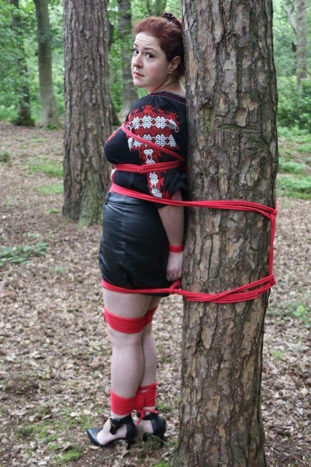 16P Thick redhead is cleave gagged and tied to a tree in a forest