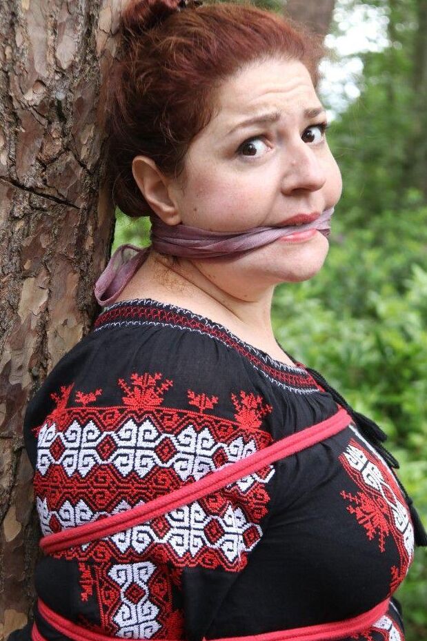 16P Thick redhead is cleave gagged and tied to a tree in a forest
