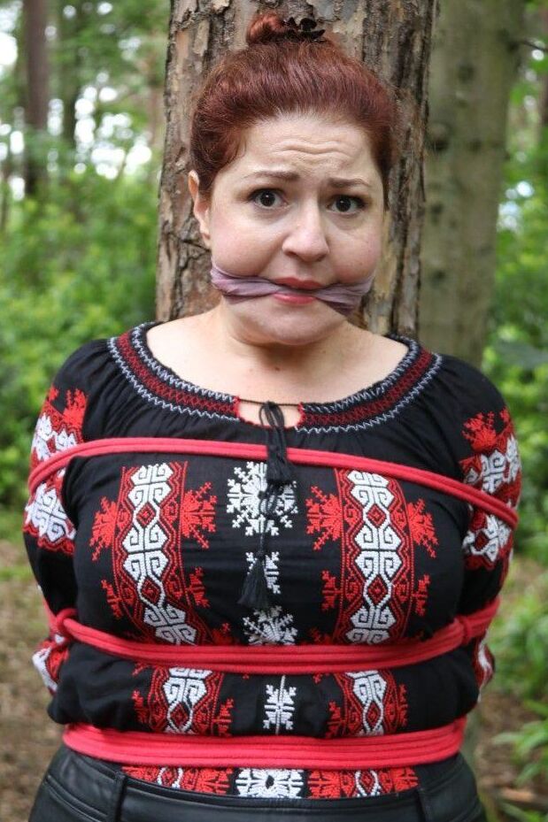 16P Thick redhead is cleave gagged and tied to a tree in a forest