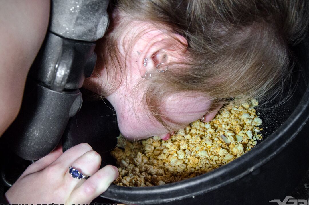 14P PAWG Electra Rayne eats from a dish while held captive in chains