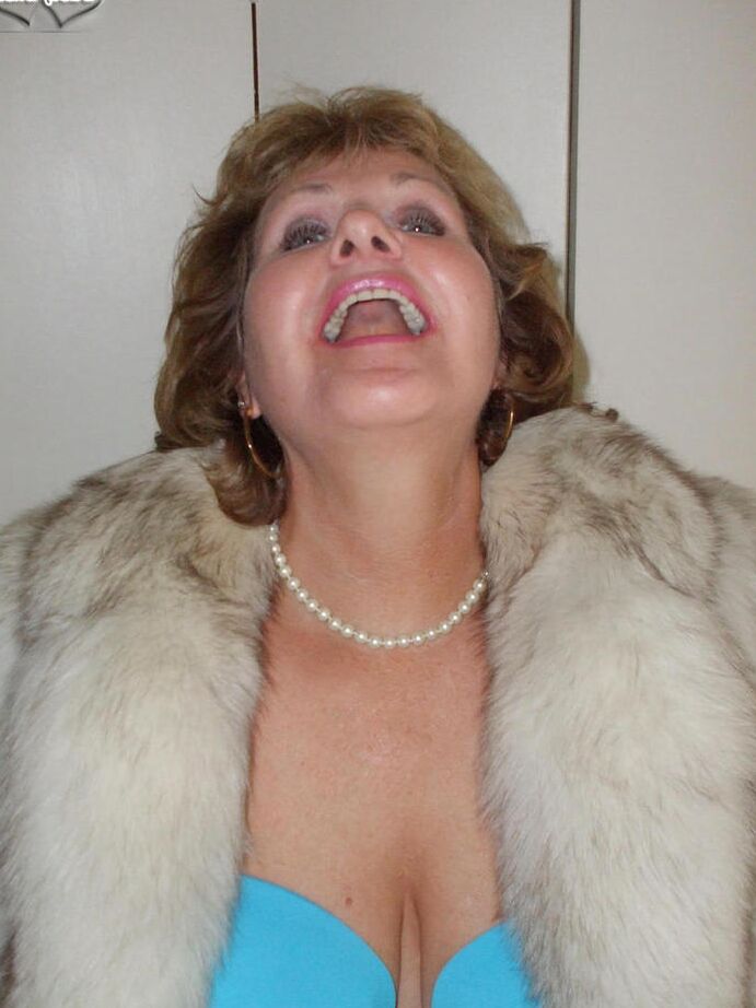 20P Mulher mais velha Busty Bliss lambe os lábios antes de mostrar os seios em um casaco de pele