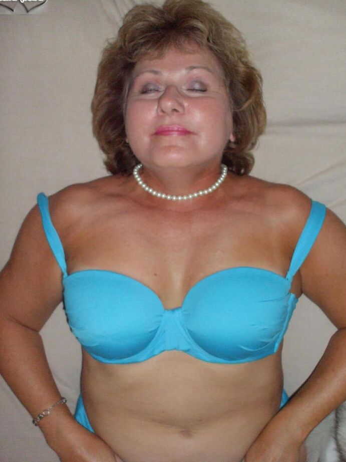 20P Mulher mais velha Busty Bliss lambe os lábios antes de mostrar os seios em um casaco de pele