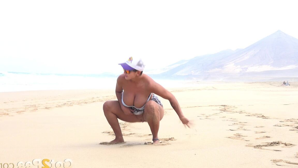 15P Caucasian female Chloe takes a piss while while traipsing on a deserted beach