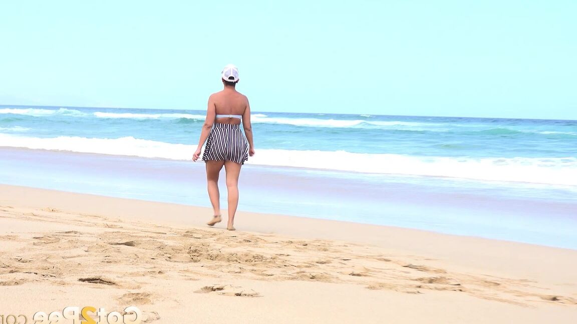 15P Caucasian female Chloe takes a piss while while traipsing on a deserted beach