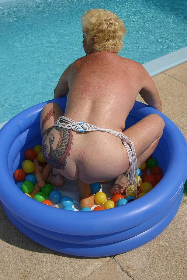 20P Mature blonde Mary Bitch dildos her snatch in a wading pool by a swimming pool