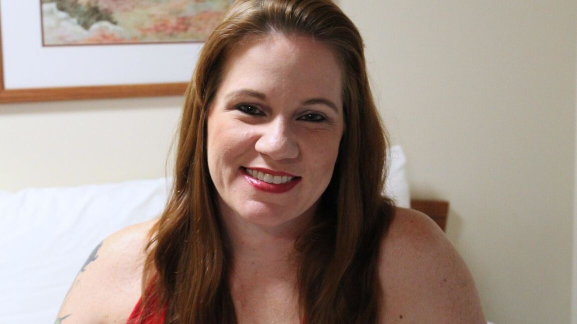 12P Redheaded plumper Ginger Reigh displays her painted toenails in a red dress