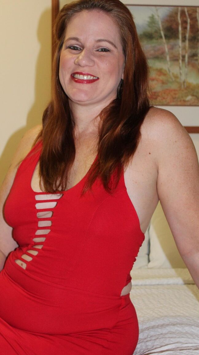 12P Redheaded plumper Ginger Reigh displays her painted toenails in a red dress