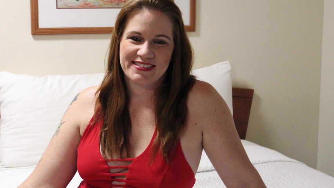12P Redheaded plumper Ginger Reigh displays her painted toenails in a red dress