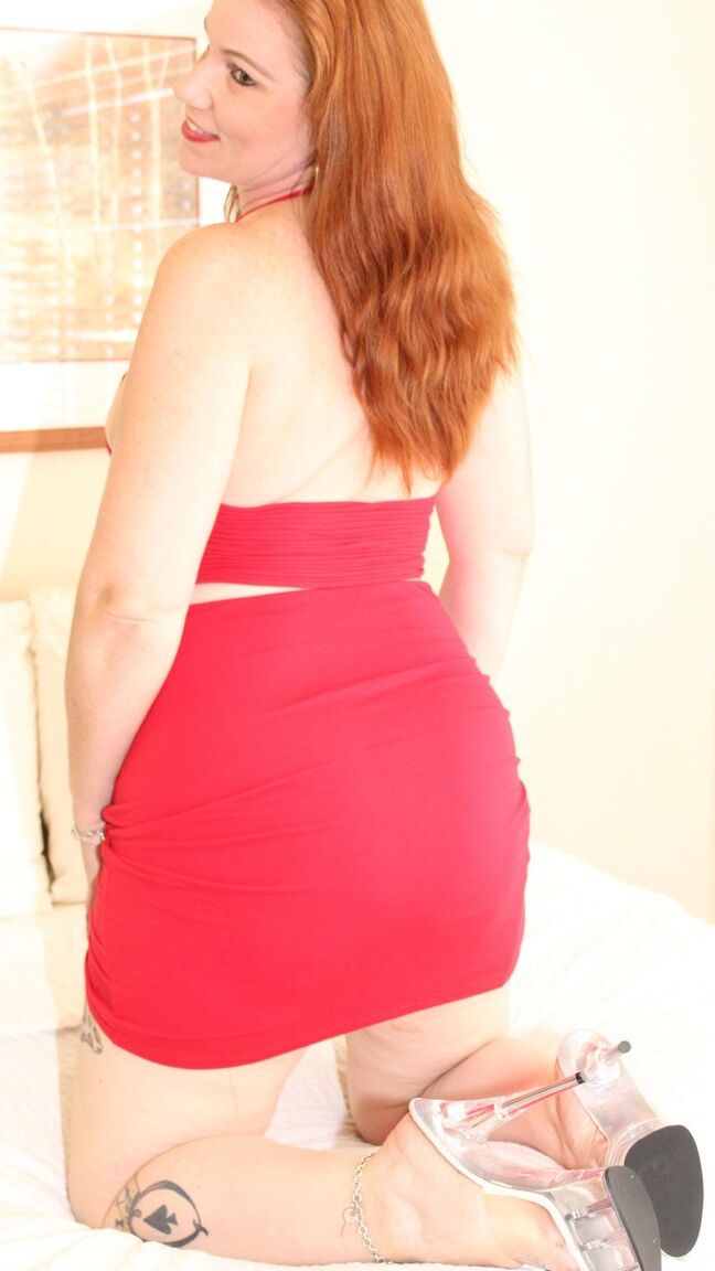 12P Redheaded plumper Ginger Reigh displays her painted toenails in a red dress