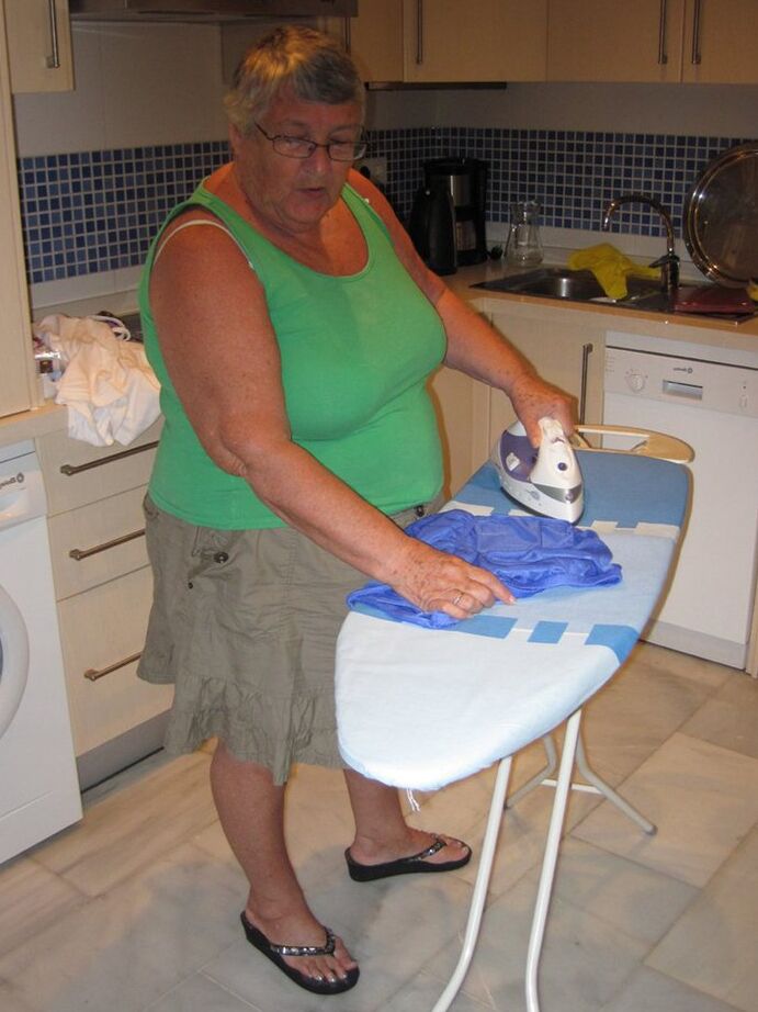 20P Oma britânica com excesso de peso, vovó Libby, expõe seus seios enquanto passa roupa