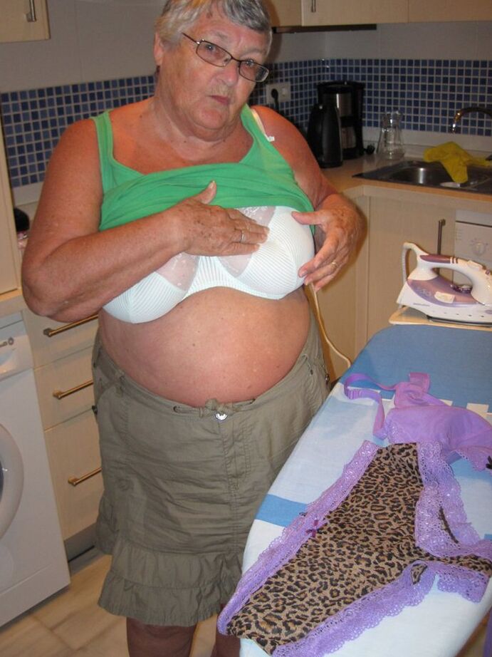 20P Oma britânica com excesso de peso, vovó Libby, expõe seus seios enquanto passa roupa