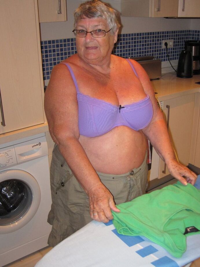 20P Oma britânica com excesso de peso, vovó Libby, expõe seus seios enquanto passa roupa
