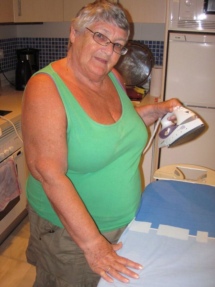 20P Oma britânica com excesso de peso, vovó Libby, expõe seus seios enquanto passa roupa