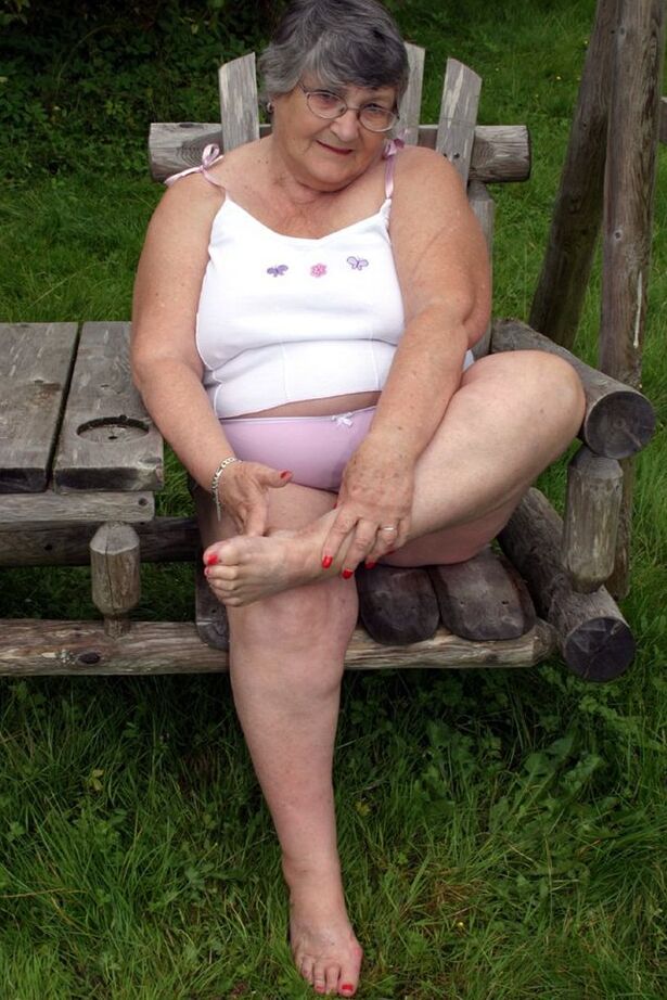 20P La abuela británica Libby expone sus tetas en un columpio en el banco del patio trasero
