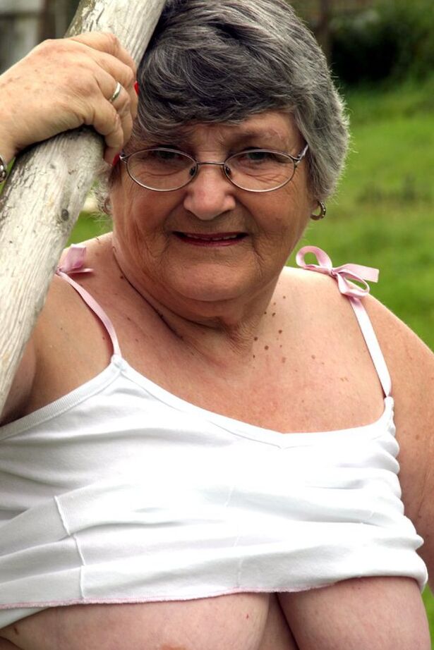 20P La abuela británica Libby expone sus tetas en un columpio en el banco del patio trasero