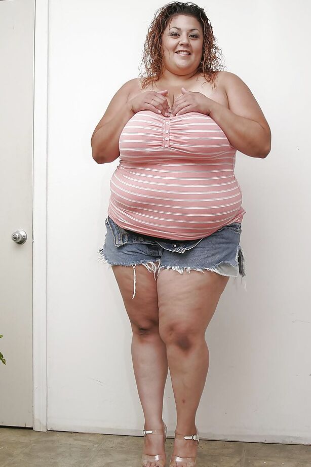 16P Dame latina extra large en short en jean se déshabillant et écartant ses lèvres inférieures
