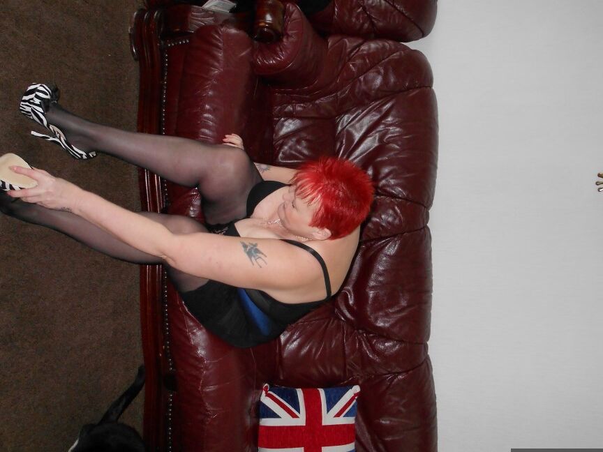 20P Mature redhead Valgasmic Exposed displays her breasts on a sofa in blue nylons