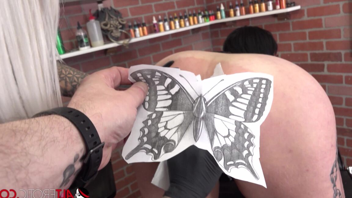 16P Une nana tatouée se fait goder la chatte tout en se faisant tatouer