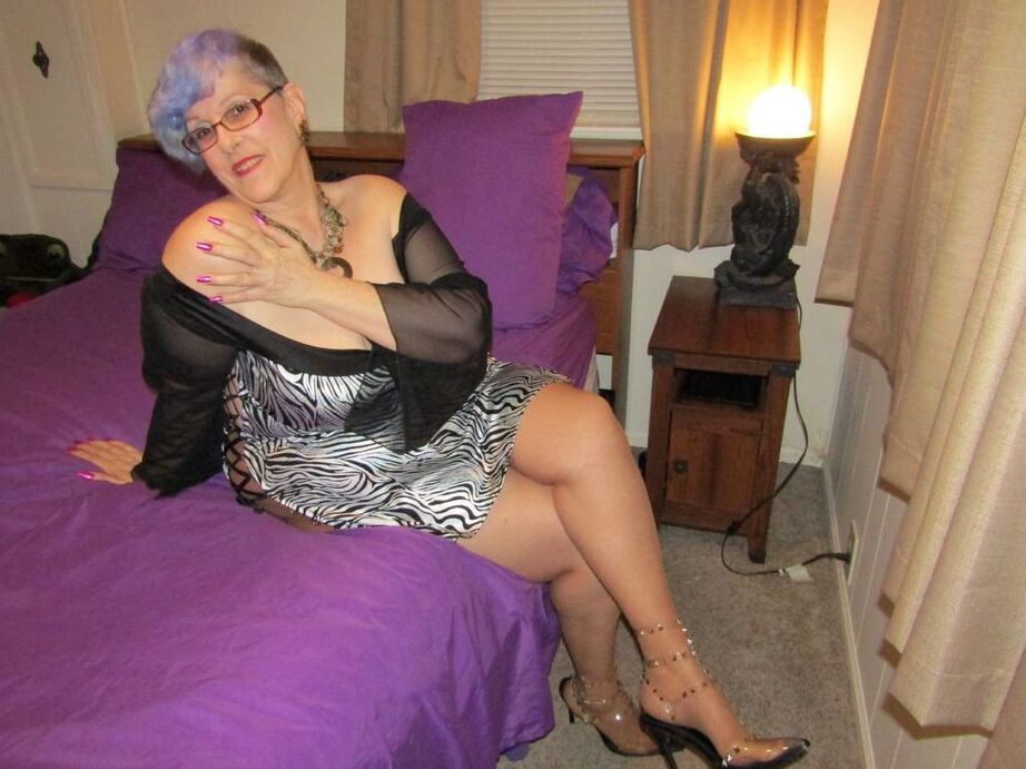 20P La anciana Bunny Gram muestra su coño cubierto de medias en una cama con zapatos puntiagudos