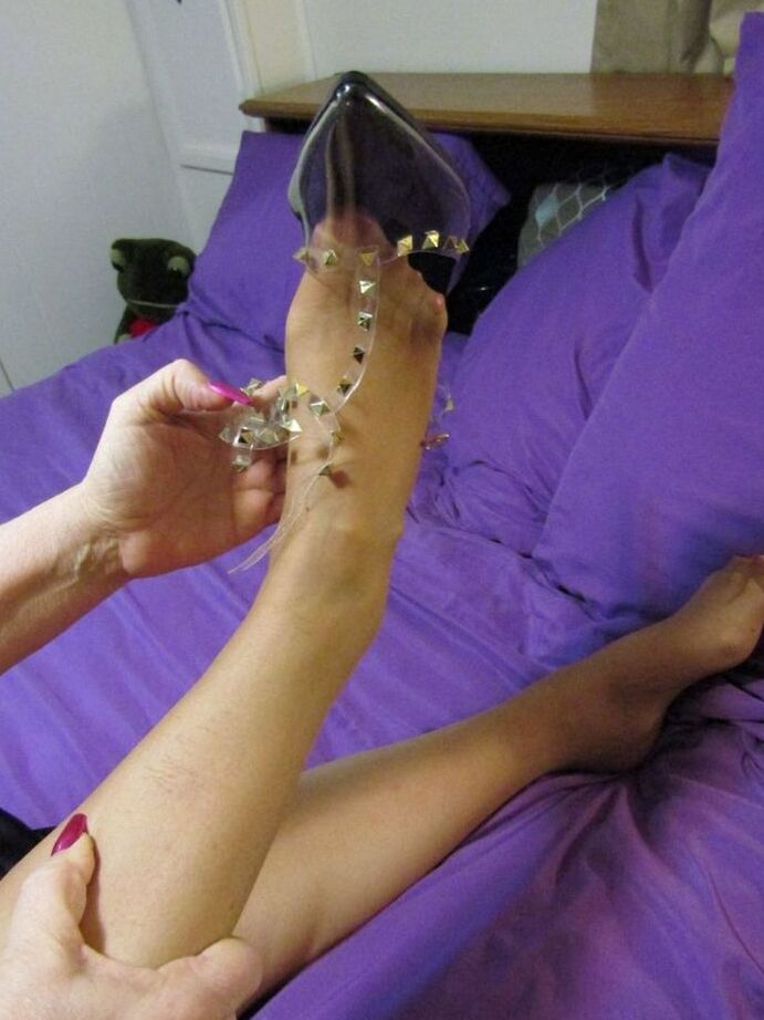 20P La anciana Bunny Gram muestra su coño cubierto de medias en una cama con zapatos puntiagudos