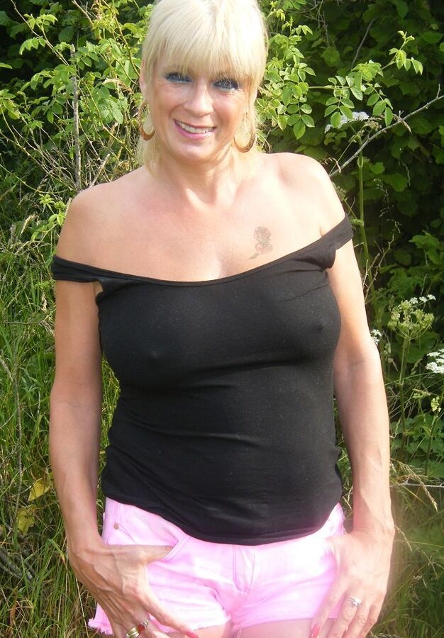 19P La MILF rubia Dimonty se desnuda con calzado cerca de unos árboles y arbustos