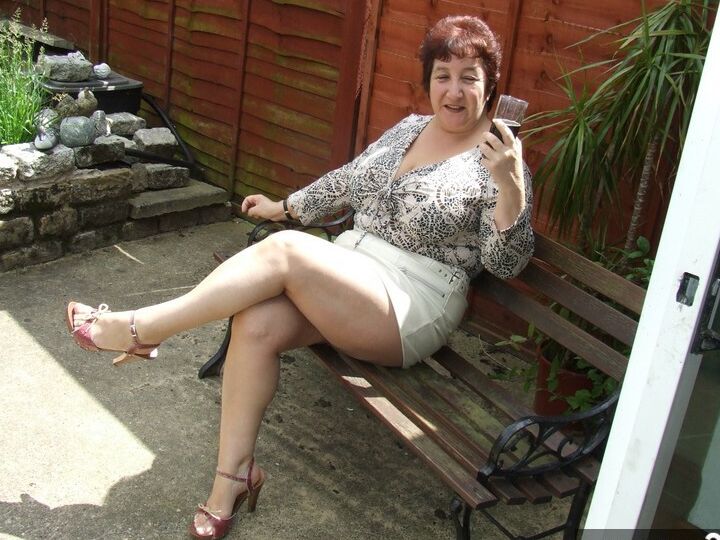 20P Madura BBW Kinky Carol muestra su ropa interior bajo la falda en un patio en sujetador