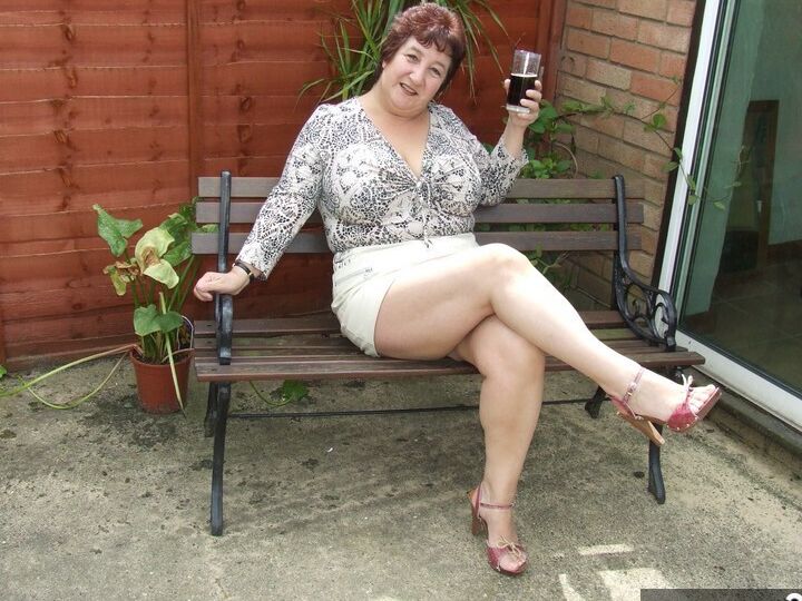 20P Madura BBW Kinky Carol muestra su ropa interior bajo la falda en un patio en sujetador