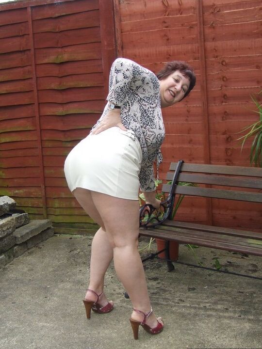 20P Madura BBW Kinky Carol muestra su ropa interior bajo la falda en un patio en sujetador