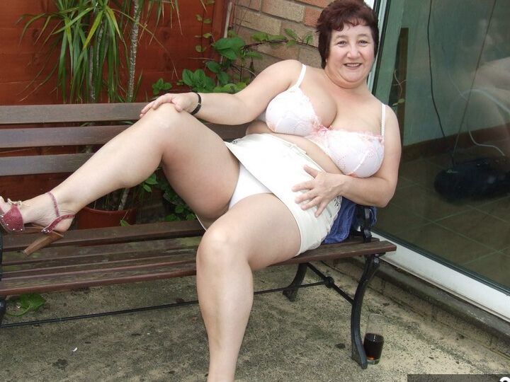 20P Madura BBW Kinky Carol muestra su ropa interior bajo la falda en un patio en sujetador