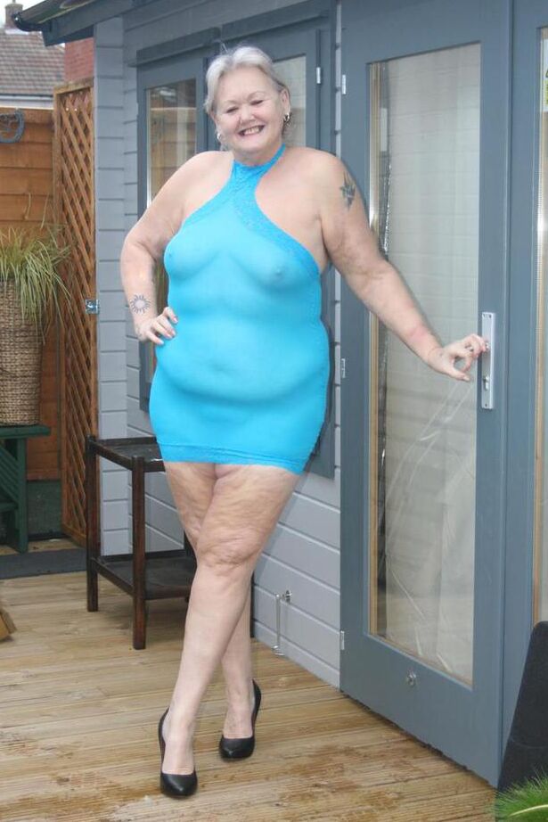 20P Abuela gorda se levanta un vestido transparente para exponer su vagina con zapatos de tacón negros