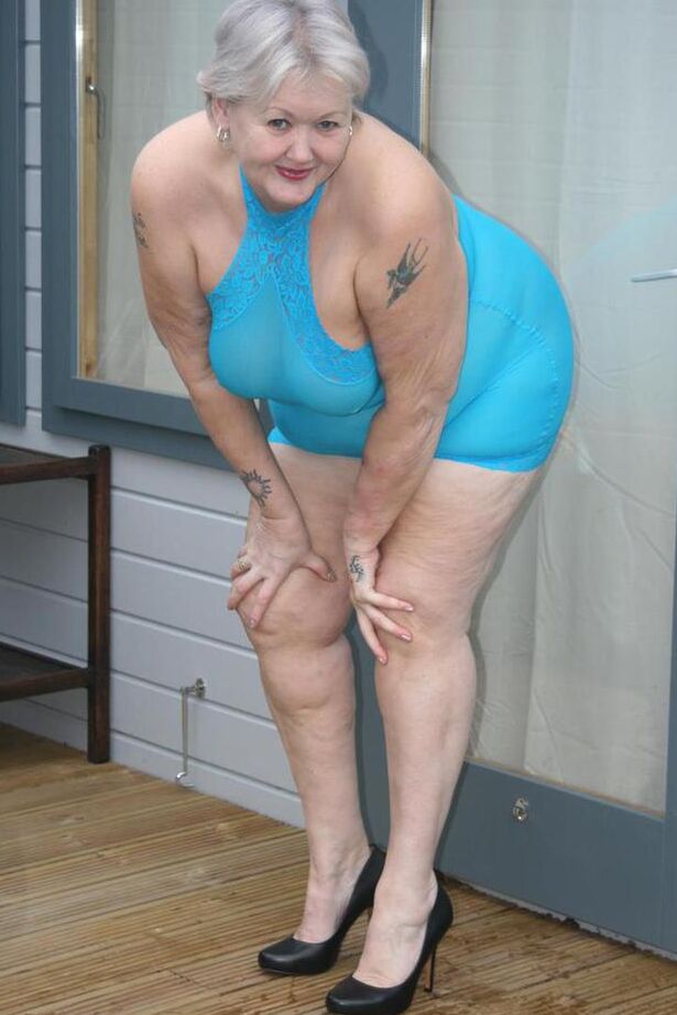 20P Abuela gorda se levanta un vestido transparente para exponer su vagina con zapatos de tacón negros