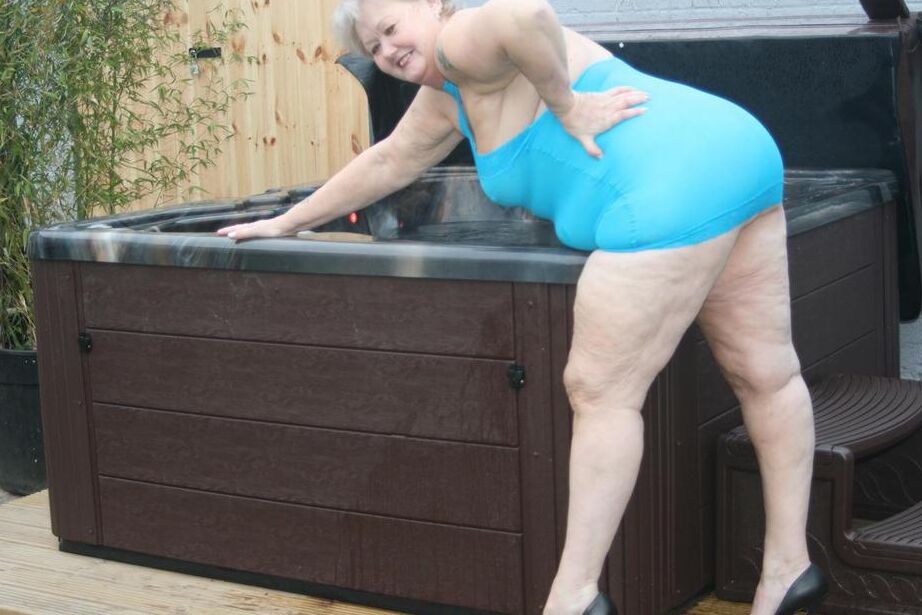 20P Abuela gorda se levanta un vestido transparente para exponer su vagina con zapatos de tacón negros