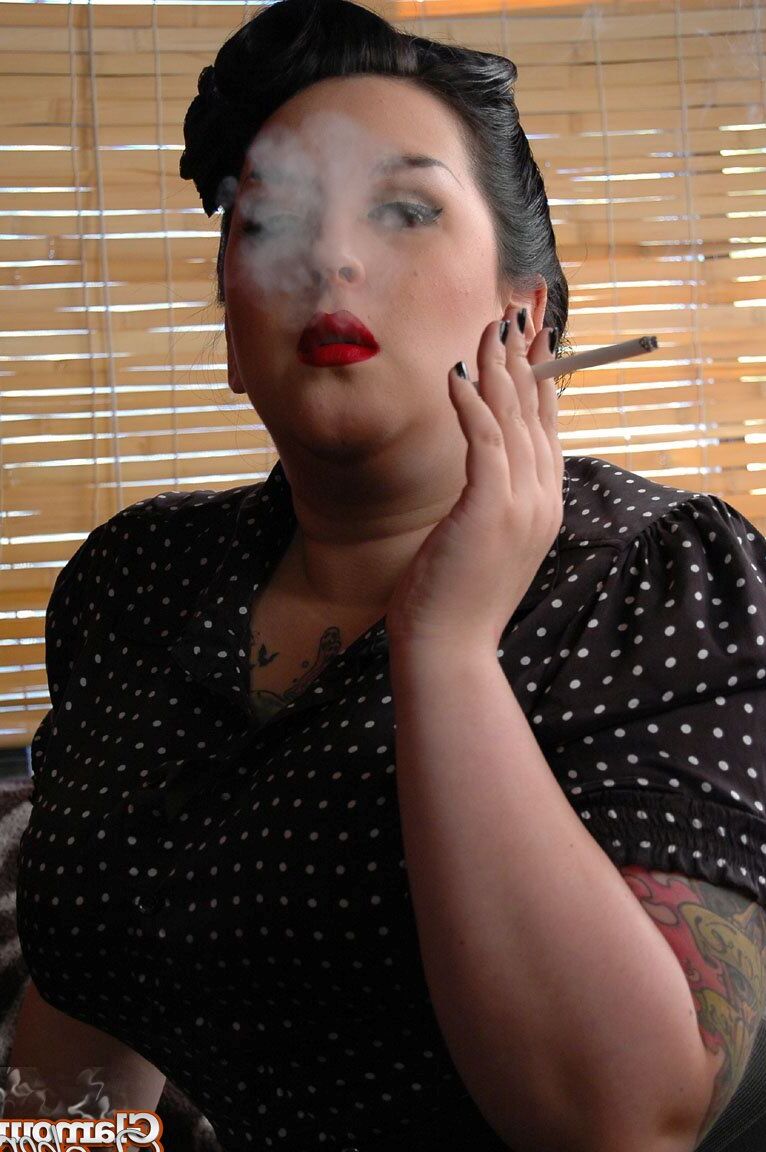 15P Fully clothed fat woman Kerosene wraps red lips around a cigarette