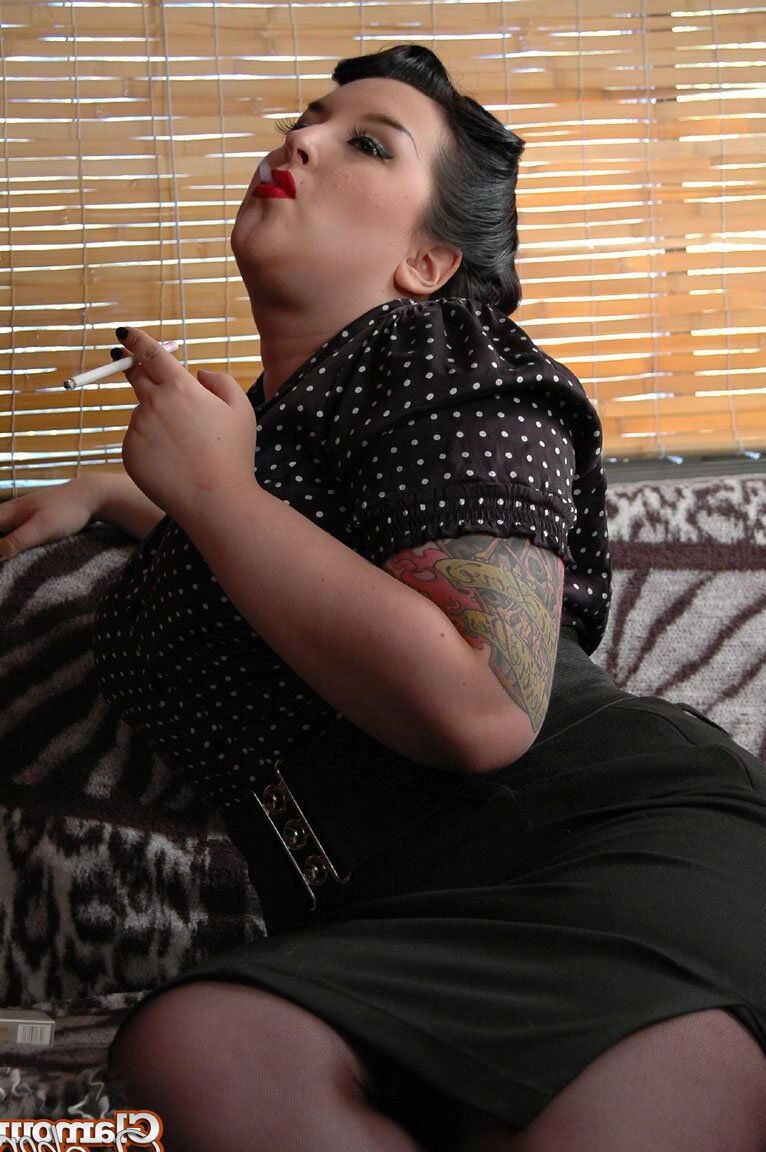 15P Fully clothed fat woman Kerosene wraps red lips around a cigarette